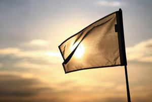 A white flag with the outline of the sun visible through it